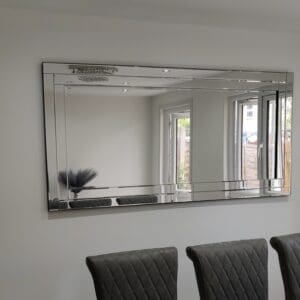 Contemporary frameless wall mirror hanging in the dining room.