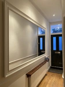 Extra large white framed mirror wall mounted landscape in the hallway entrance.