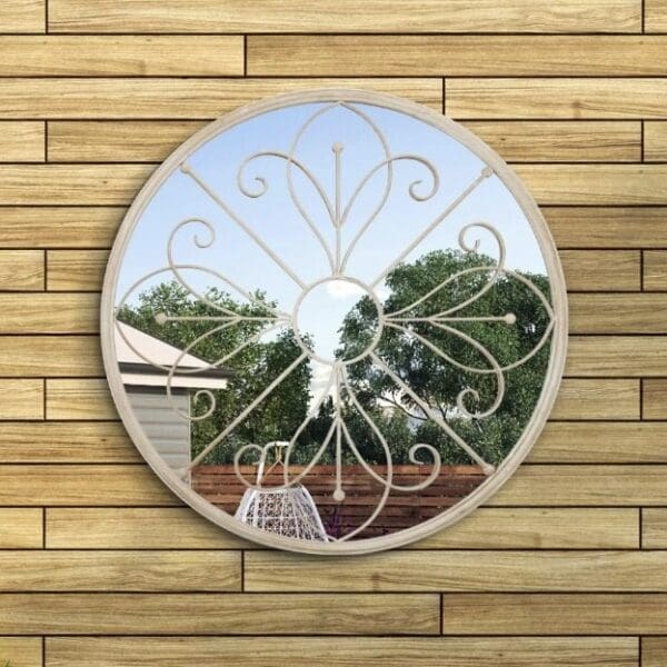 Round outdoor mirror. Mounted on the garden fence. Reflecting a tree.