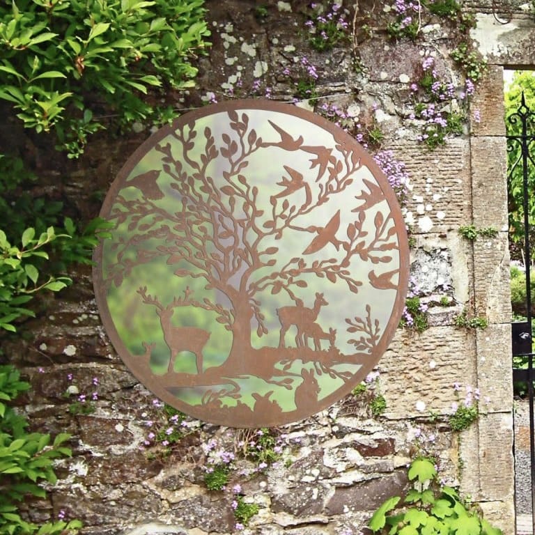 Round garden mirror wall mounted on an outdoor wall. Features wildlife scenes. 