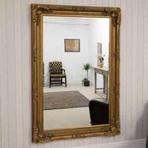 Extra large gold framed mirror. Wall mounted in the living room. Bevel edge glass.