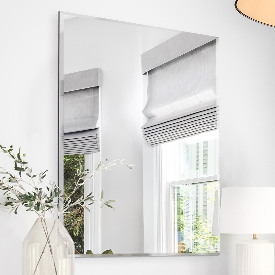 Benefits of a wall mounted all glass frameless mirrors. Mirror features a bevel edge, hung in the living room.