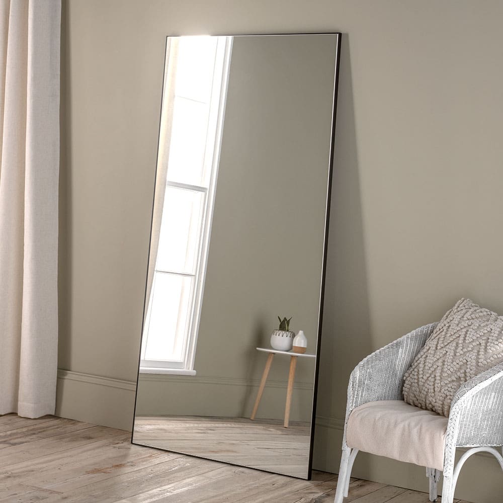 Bespoke Portobello mirror. Features a narrow black frame. Leaning against the wall. Can be made to measure.