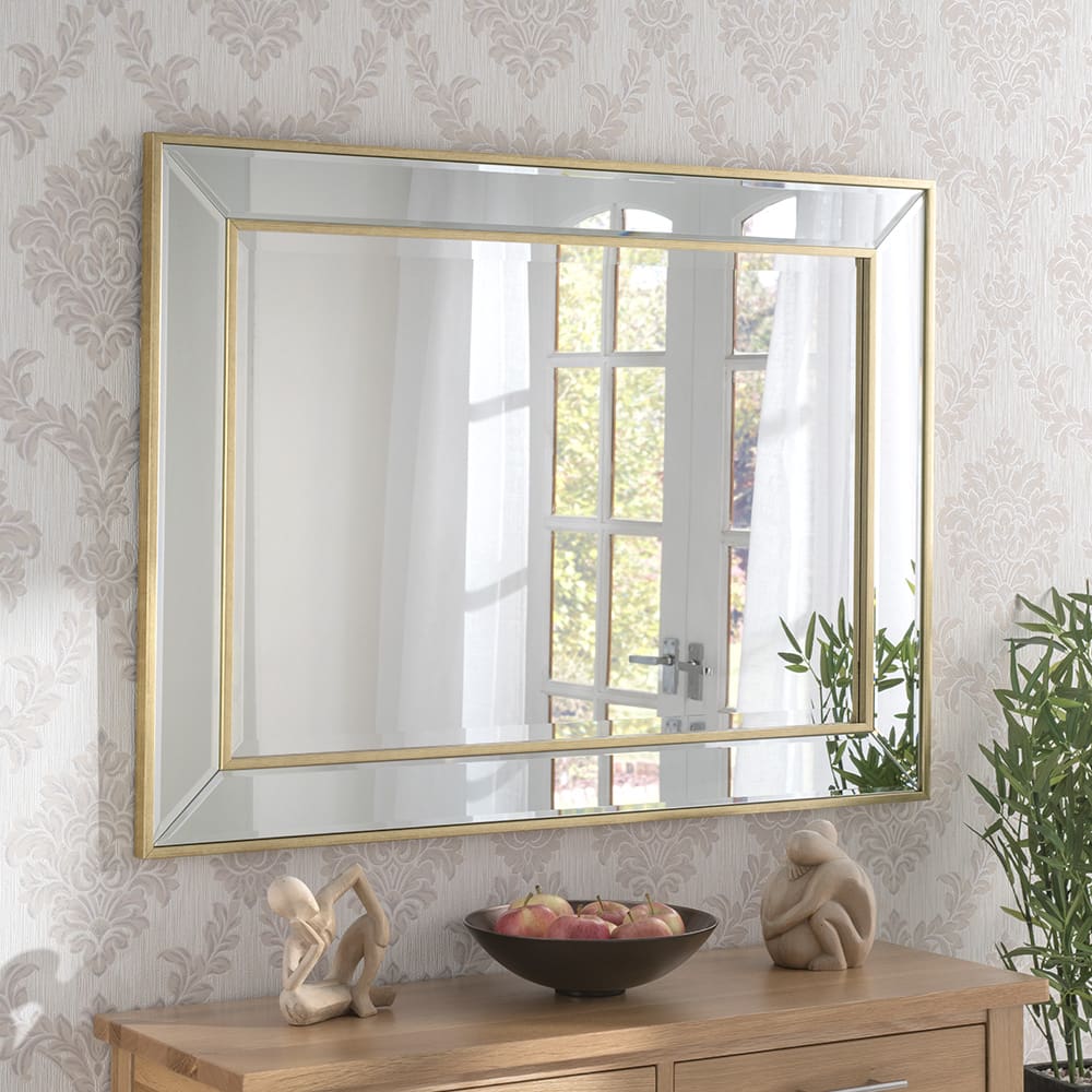 Bespoke Regent mirror. Wall mounted above living room furniture. Features a narrow gold leaf frame. Can be made to measure.