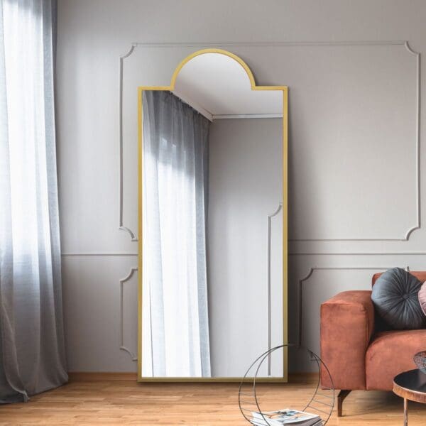 Capitol Dome Gold Metal Mirror. Gold mirror leaning against living room wall.