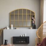 Stanmore Gold Metal Arch Mirror Wall Mounted above the Fireplace